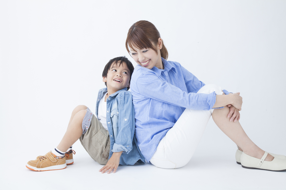 背中合わせで笑う親子